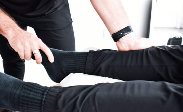 Physiotherapist applying manual therapy techniques to a patient’s knee, helping with Runner’s Knee pain relief and recovery.