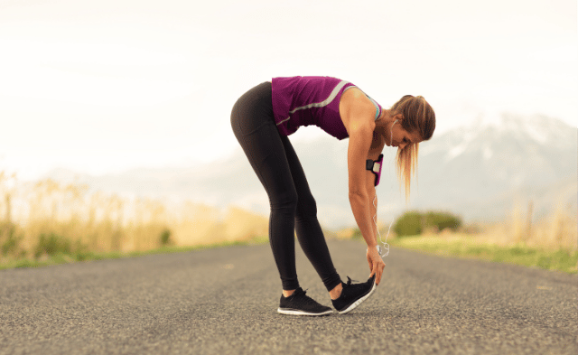 Runner stretching calves to prevent Achilles tendon pain in Vancouver.